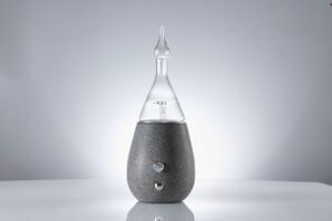 Concrete and glass nebulizing diffuser on a table in a minimalist room