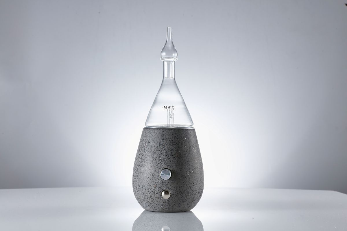 Concrete and glass nebulizing diffuser on a table in a minimalist room